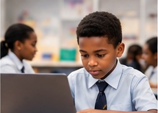A learner working at a laptop in a classroom