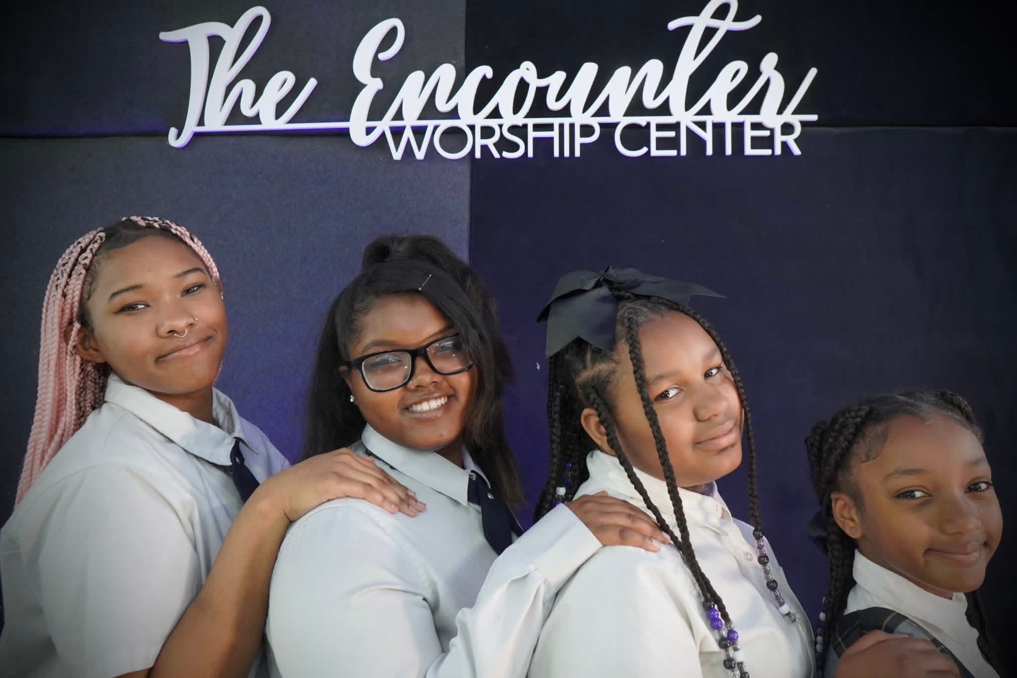 Four EWCCA students standing together in their school uniforms